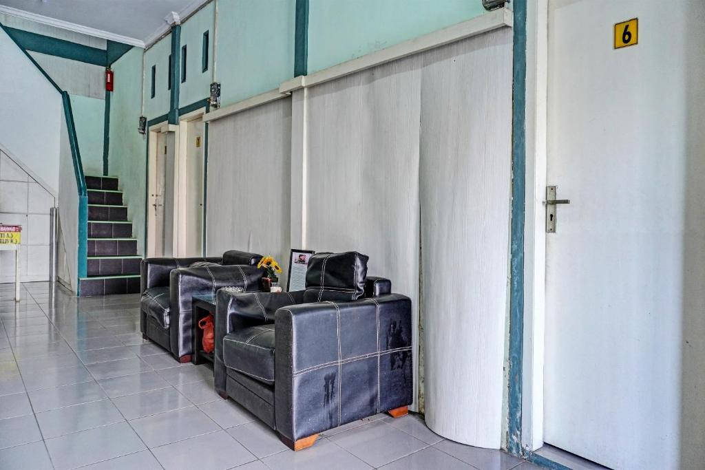 una habitación con 2 sofás y una pared en OYO 91731 Home Stay Elis Cateliya Syariah, en Karawang