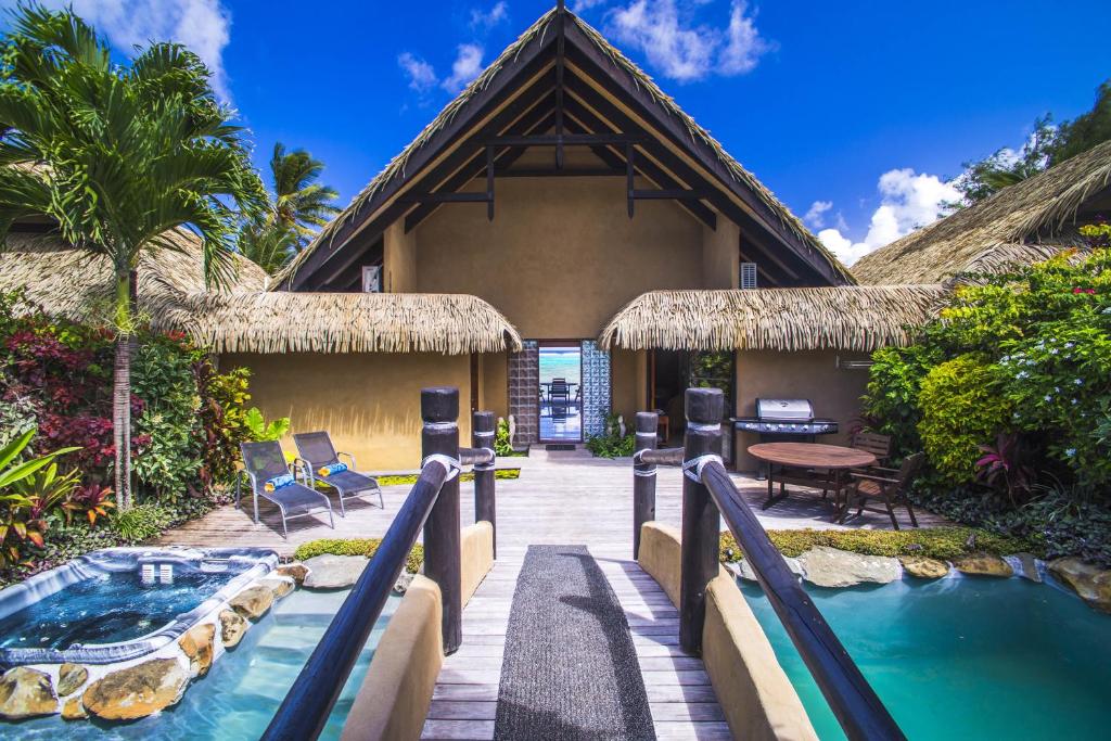 a resort with a swimming pool and a house at Rumours Luxury Villas & Spa in Rarotonga