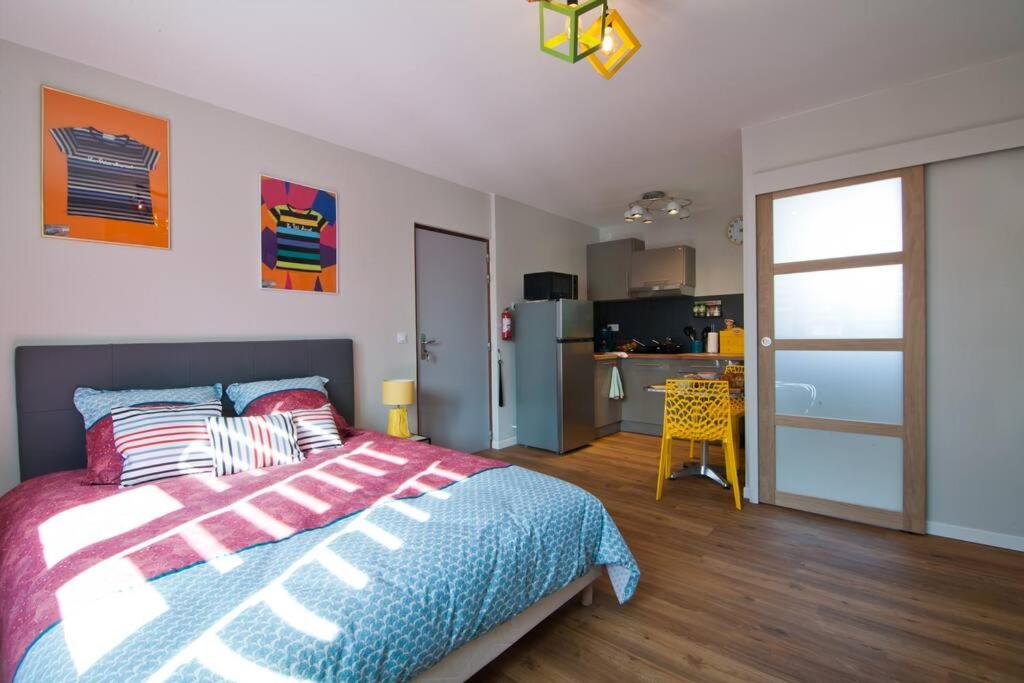 1 Schlafzimmer mit einem Bett und einer Küche in der Unterkunft Le petit Marcel - Saint-Julien-les-Villas in Saint-Julien-les-Villas