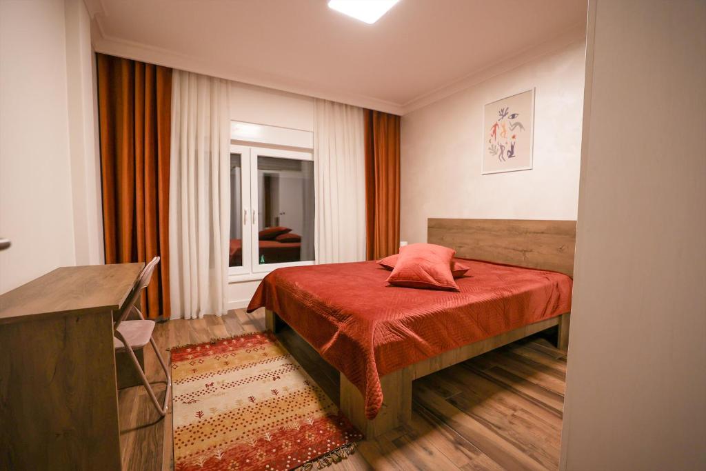 a bedroom with a bed with a red blanket at Moments Villas Premium, Prevalle in Prizren