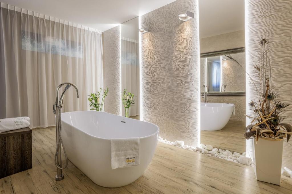 a bathroom with a large tub and two sinks at Hotel Beta in Bzenec