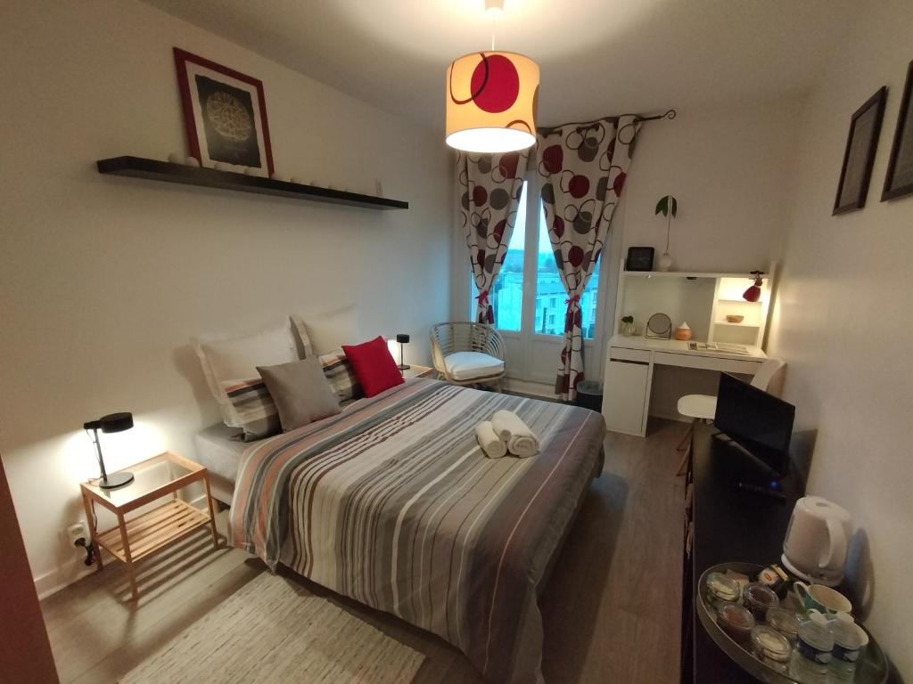 um quarto com uma cama, uma mesa e uma janela em Chambre chez l'habitant proche centre em Brest