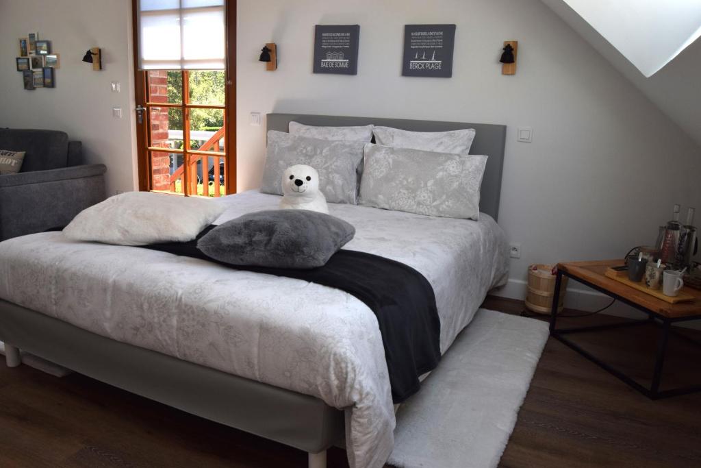 - une chambre avec un lit avec un animal rembourré dans l'établissement Les chambres d hôtes de l entre deux baies à Merlimont entre Berck et le Touquet, à Merlimont