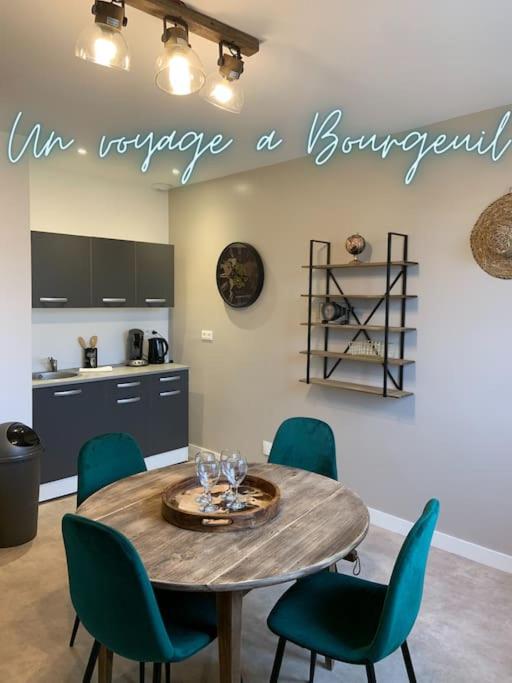 a kitchen with a table with chairs and a sign that reads im voyaging at Un voyage à Bourgeuil in Bourgueil