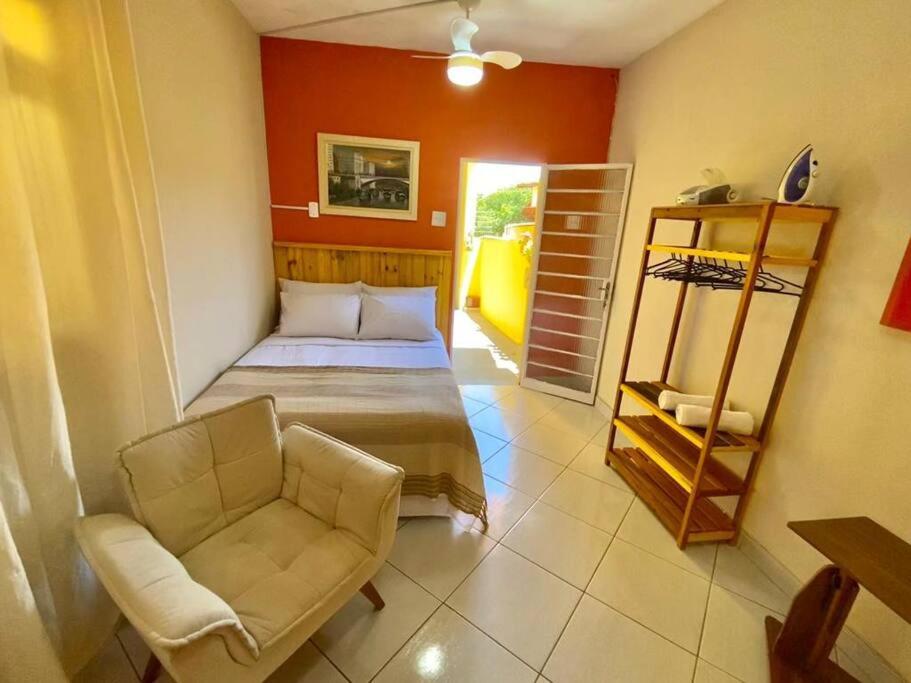 a bedroom with a bed and a chair in a room at Aconchego Mineiro com Garagem in Belo Horizonte