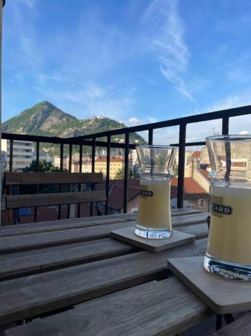 deux verres de bière assis sur une table en bois dans l'établissement St Bruno - Studio « Palmiers », à Grenoble
