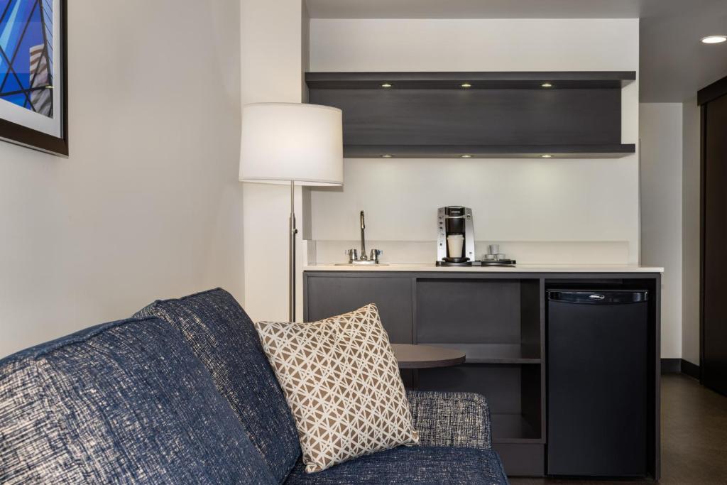 a living room with a couch and a kitchen at Holiday Inn Toronto Downtown Centre by IHG in Toronto