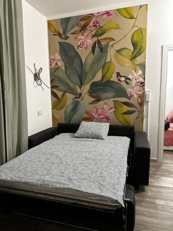 um quarto com uma cama com papel de parede floral em Casa Raf San Salvario em Turim