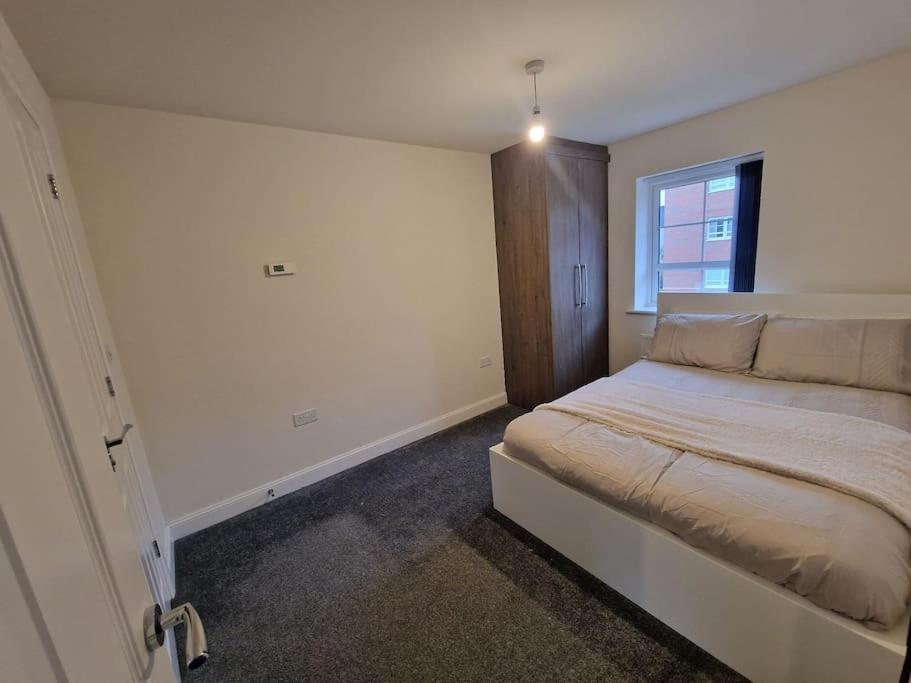a bedroom with a large bed with a window at Comfy 3 bed home in Nottingham