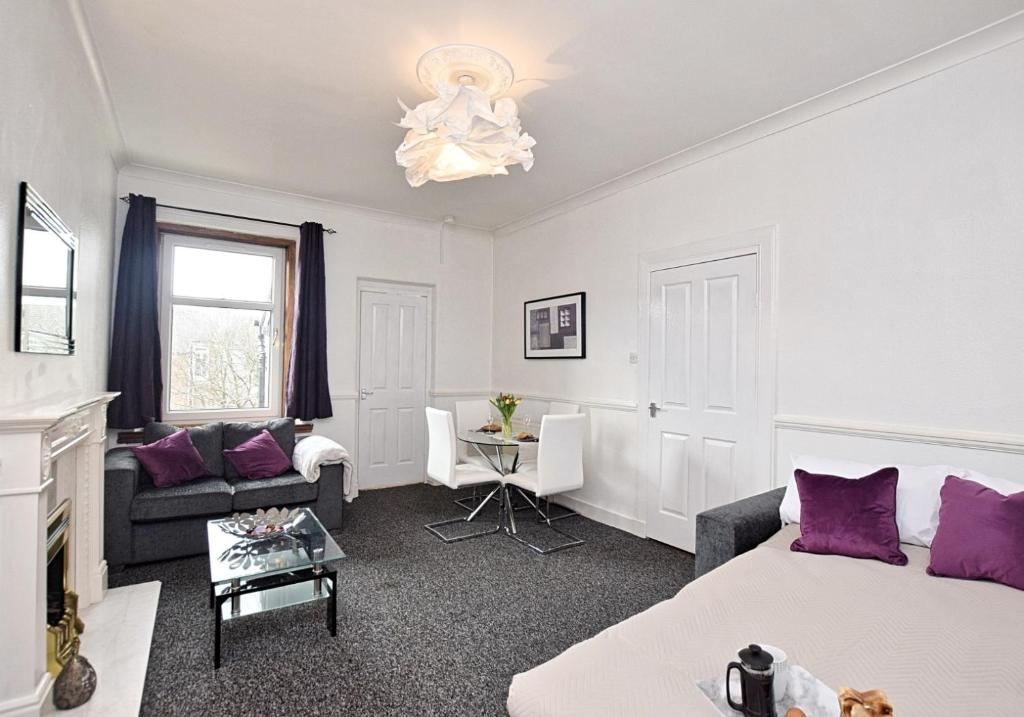 a living room with a bed and a couch at Whifflet Apartment by Klass Living Coatbridge in Coatbridge