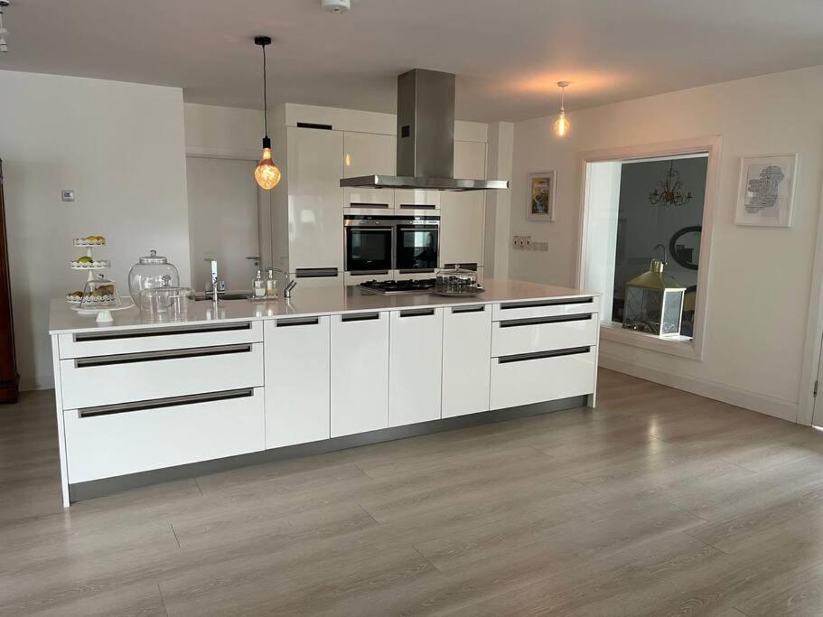 uma grande cozinha com armários brancos e uma bancada em Spacious and Cozy Home with Ocean Views em Lifford