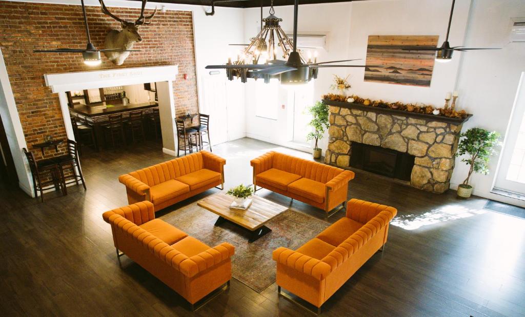 a living room with orange furniture and a fireplace at Hunter Arms Hotel in Saint Cloud