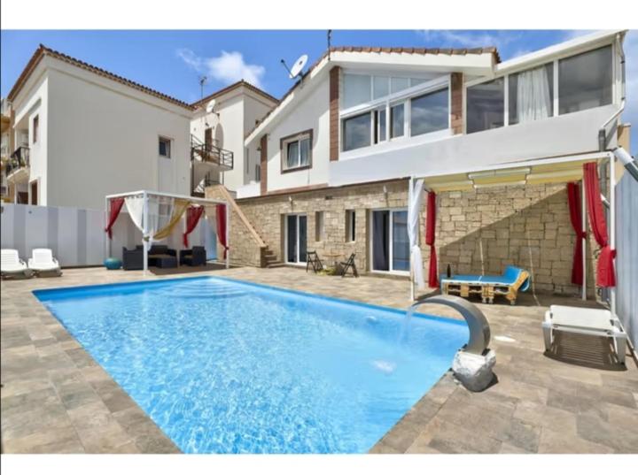 a swimming pool in front of a house at Mes 5 Bijoux in Arona