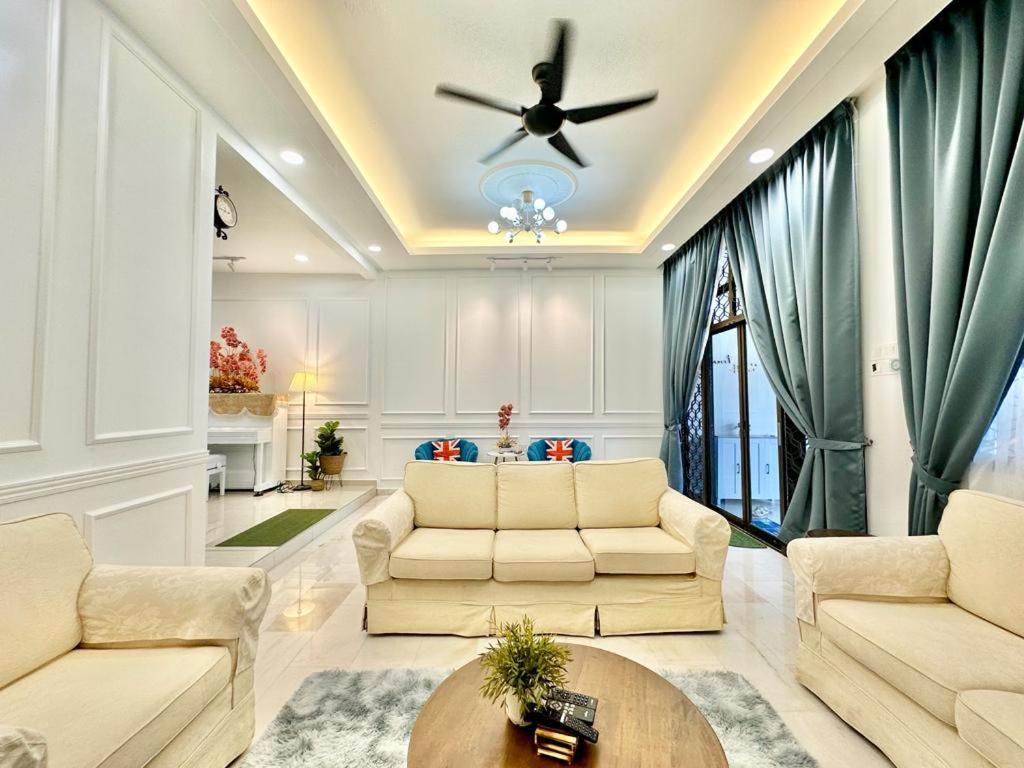ein Wohnzimmer mit 2 Sofas und einem Deckenventilator in der Unterkunft 38 villa homestay in Muar