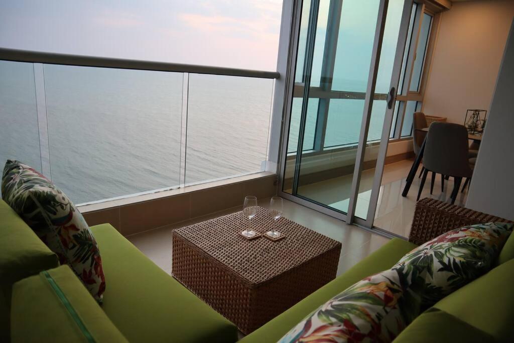 salon z zieloną kanapą i stołem w obiekcie Palmetto Sunset 2903 with an amazing ocean view w mieście Cartagena de Indias