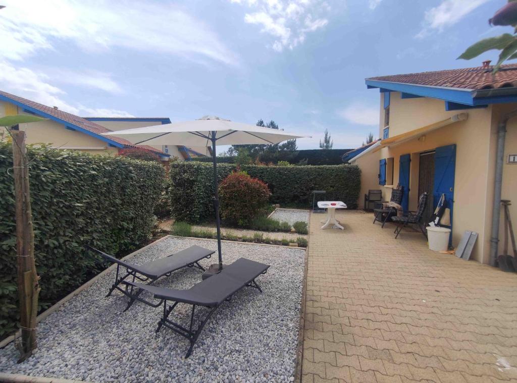 Village Océlandes 187 في سان جوليان-أون-بورن: فناء مع كرسيين ومظلة