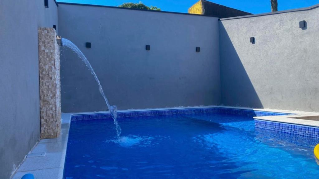 a swimming pool with a water fountain at casa_litoral_mongagua_2022 in Mongaguá