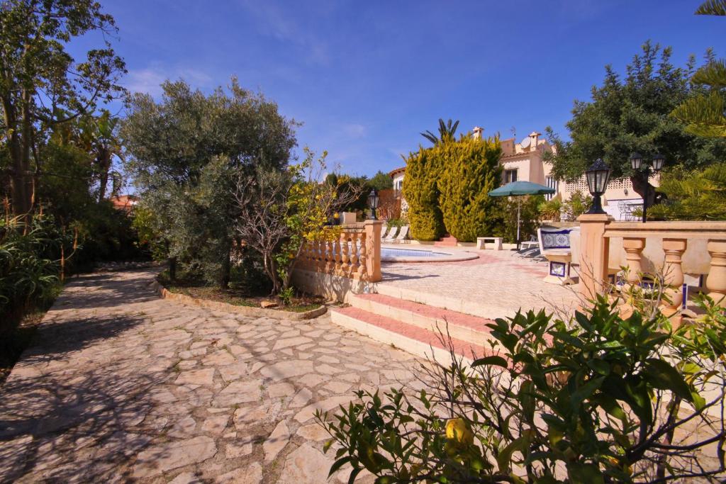 a patio with stairs and a fence and trees at Villa Carmen - Plusholidays in Calpe