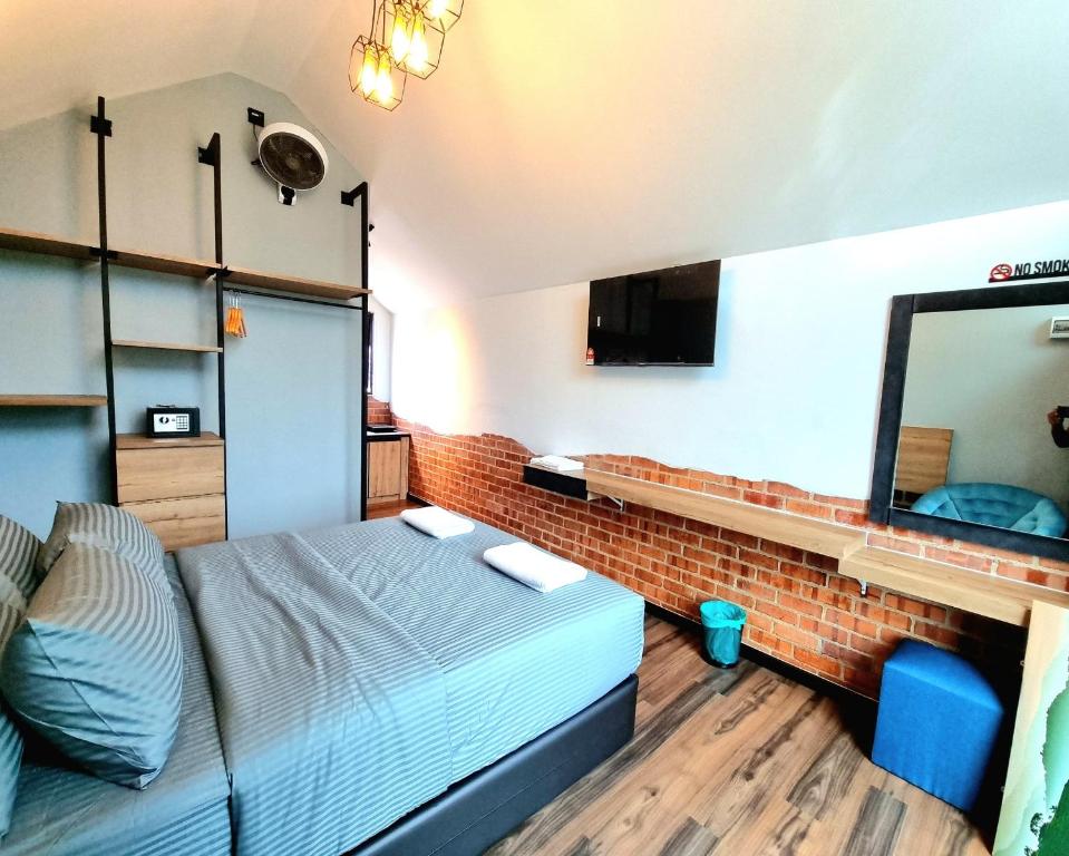 a bedroom with a bed and a brick wall at Campod Resort @ Cameron Highlands in Cameron Highlands
