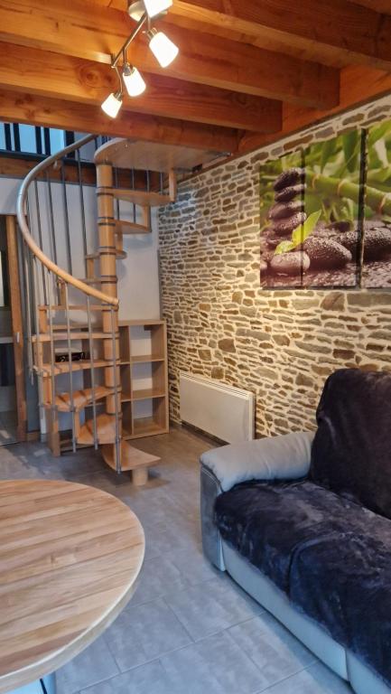 Una sala de estar con un sofá y una pared de ladrillos. en gites 2 beauvoir, en Beauvoir
