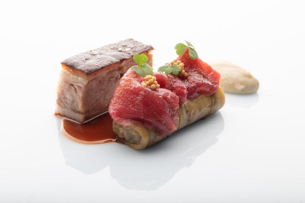 a piece of meat with sauce and a piece of bread at Palazzo Tirso MGallery Cagliari in Cagliari