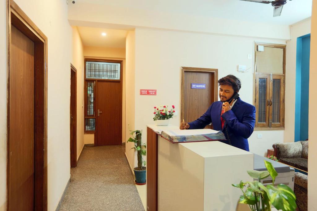 a woman standing at a counter in an office at Hotel Ginger Palace - Corporate stay business hotel in Noida
