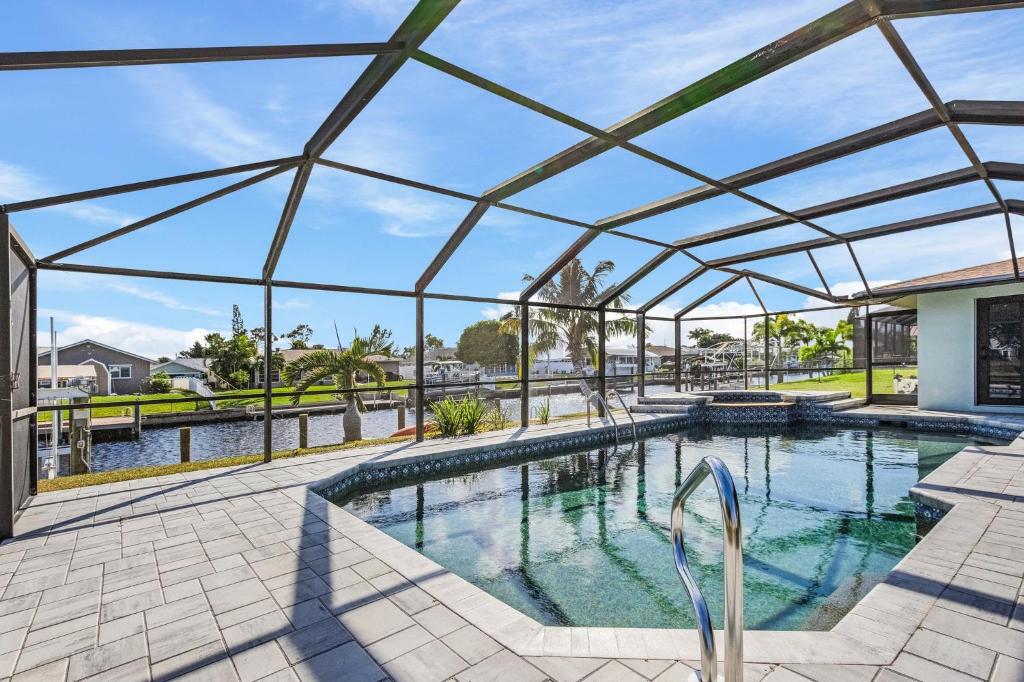 a swimming pool with a pergola over it at Direct Sailboat Access & Southern Exposure Heated Pool - Villa Coconut Hideaway - Roelens in Cape Coral