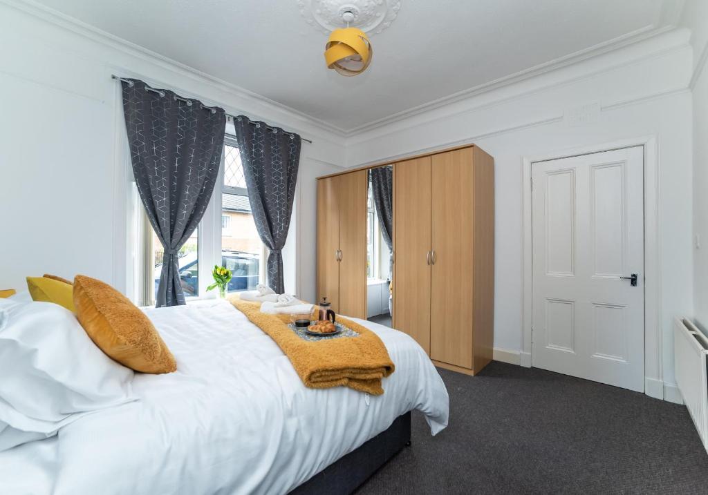 Un dormitorio con una gran cama blanca y una ventana en Albion Apartment by Klass Living Coatbridge en Coatbridge