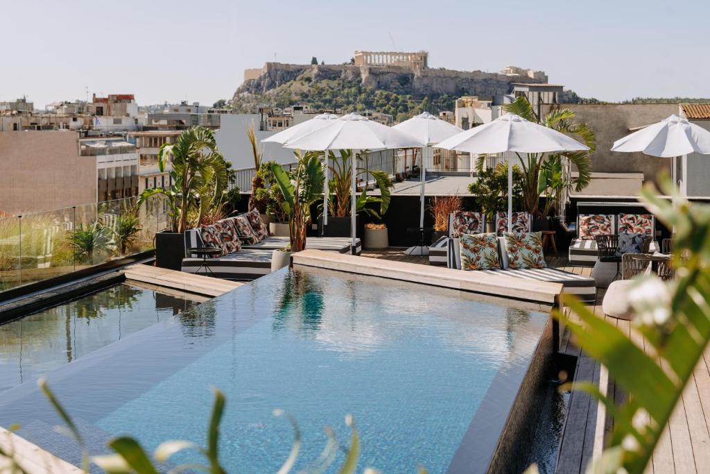 a swimming pool with chairs and umbrellas on a building at Skylark, Aluma Hotels & Resorts in Athens