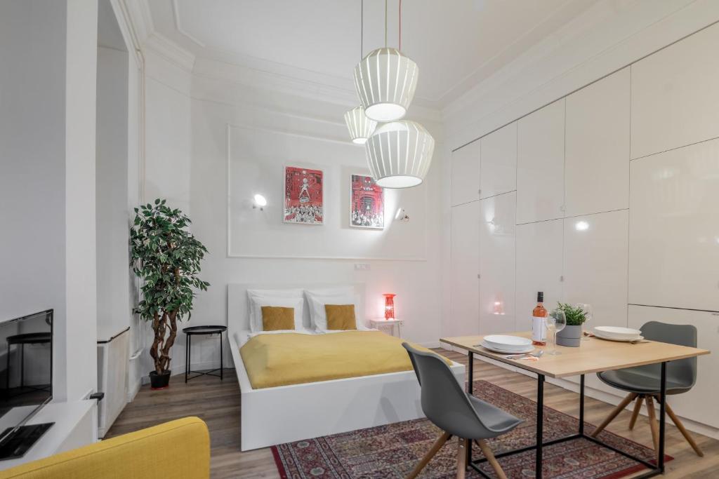 Extra Central Modern Studio في بودابست: غرفة نوم بسرير وطاولة وكراسي