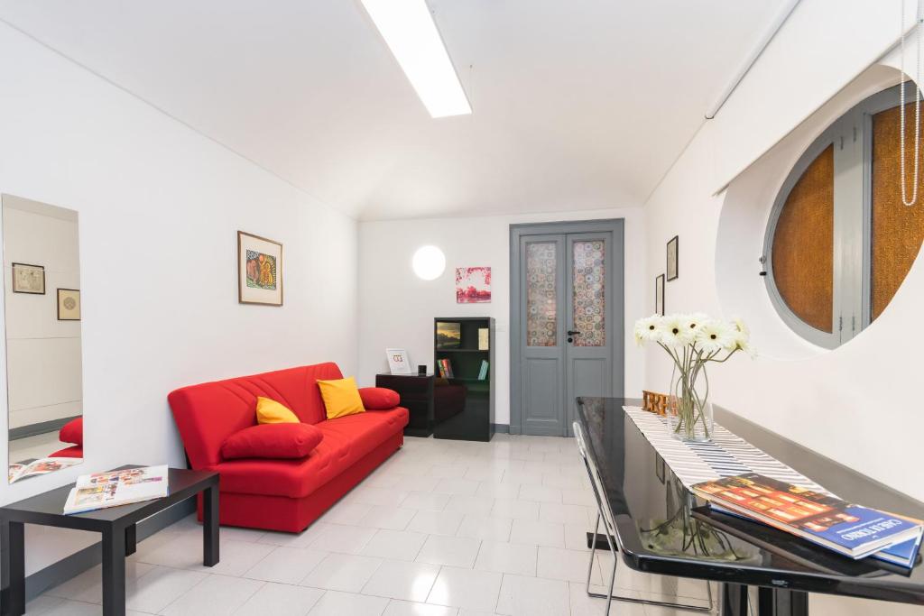 ein Wohnzimmer mit einem roten Sofa und einem Tisch in der Unterkunft Casa Lagrange by Wonderful Italy in Turin