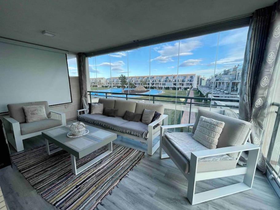 a living room with couches and a large window at Casa Calinka in Sant Jordi