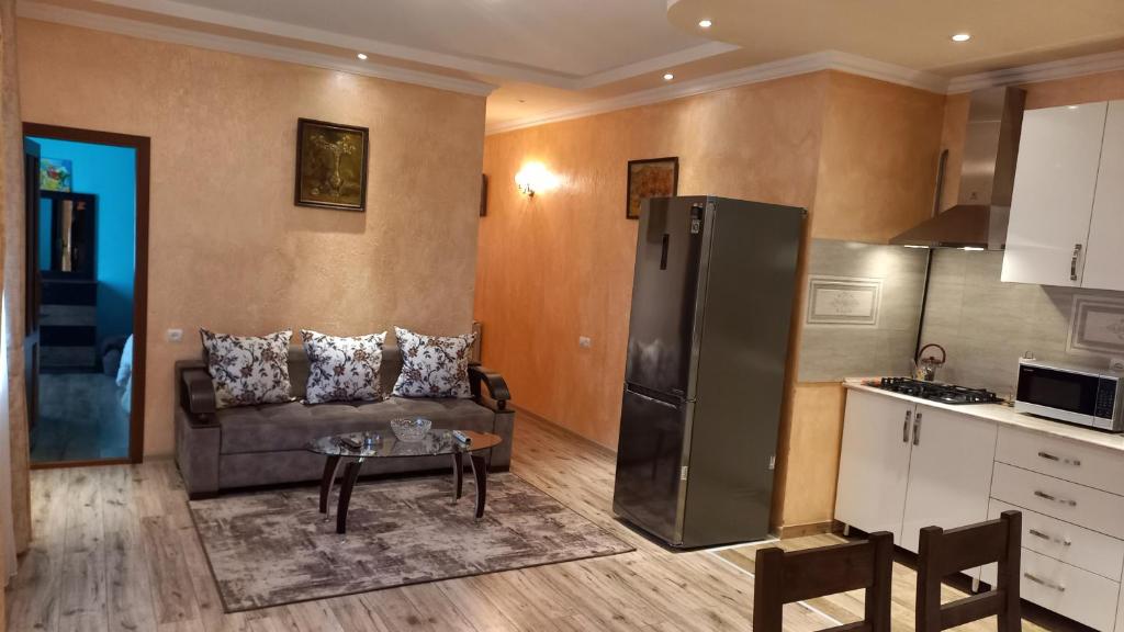 a kitchen and a living room with a couch and a refrigerator at Cottage Green Garden in Tsaghkadzor