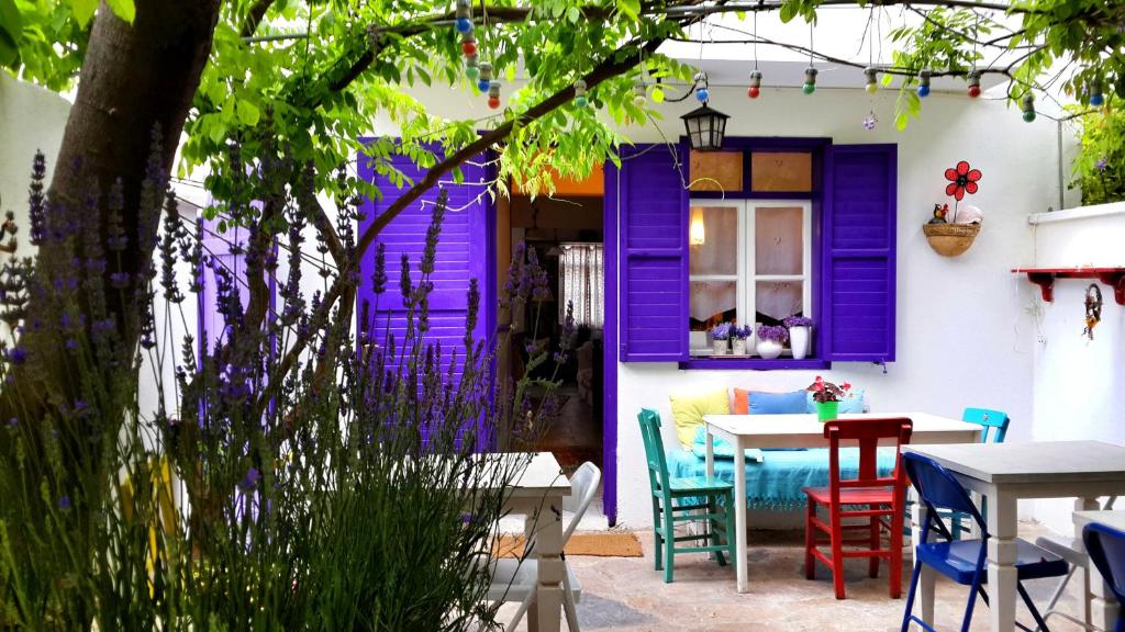 a purple door on a house with a table and chairs at Amaranda Ada Evi in Bozcaada