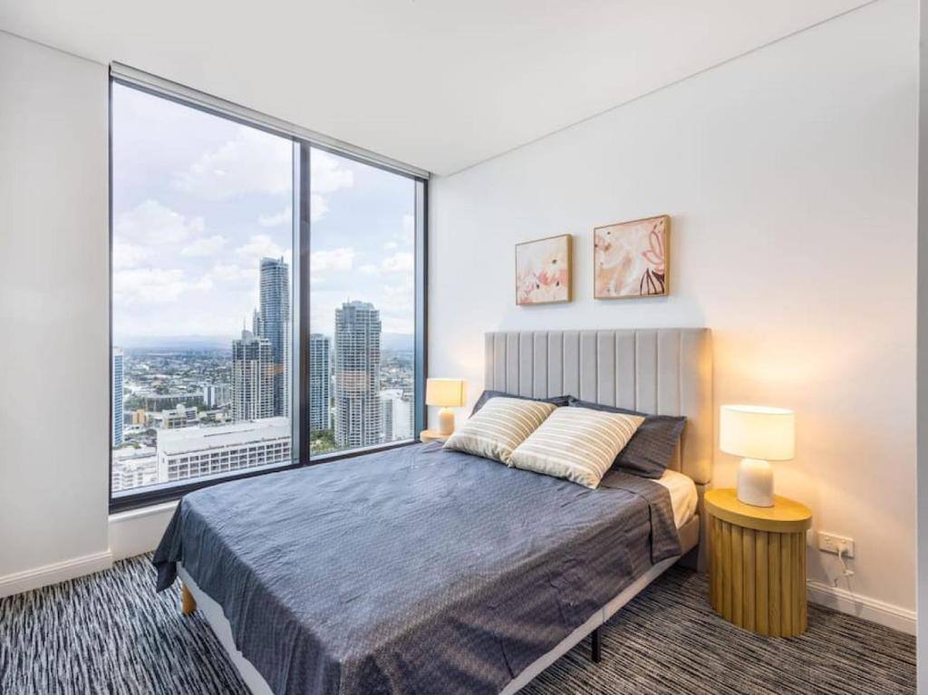 a bedroom with a bed and a large window at Location Oceanview luxury 1BR Apt steps to beach in Gold Coast