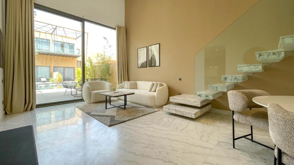 salon ze schodami, kanapą i krzesłami w obiekcie Duplex Ana - Appartement design à Marrakech w Marakeszu