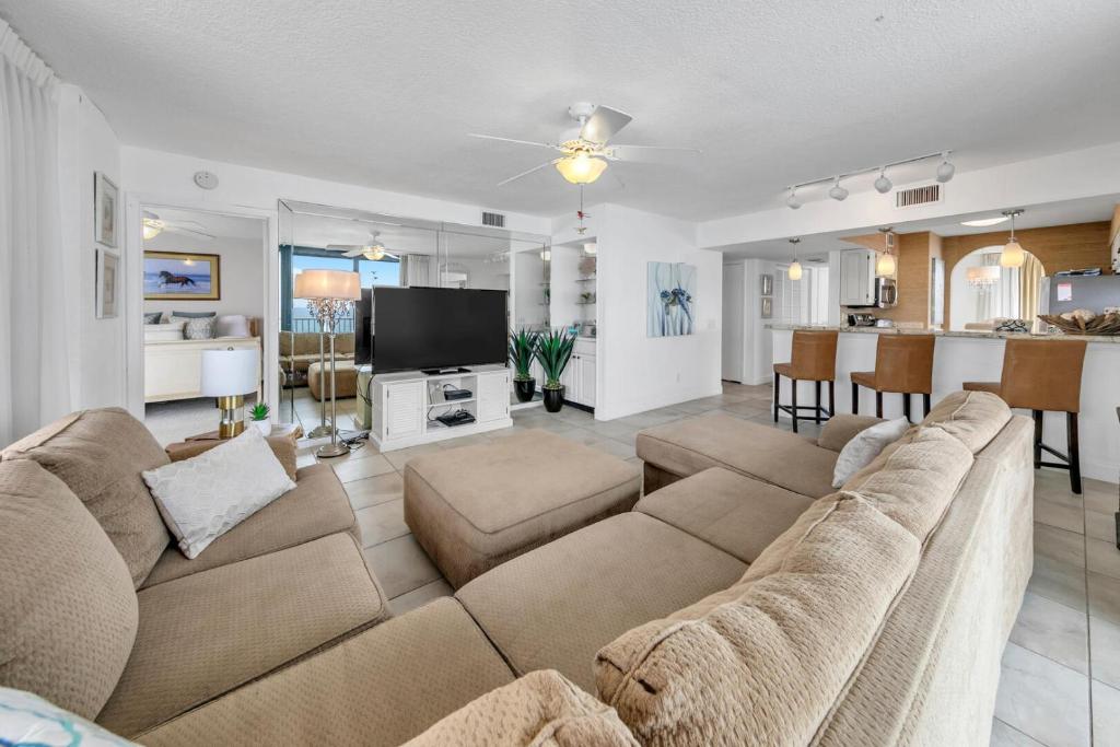 a living room with a large couch and a kitchen at Mainsail 131 - Beachfront 2BR with Free Seasonal Beach Service in Destin