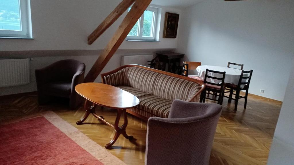 a living room with a couch and a table and chairs at Apartment in Ossiach in Altossiach