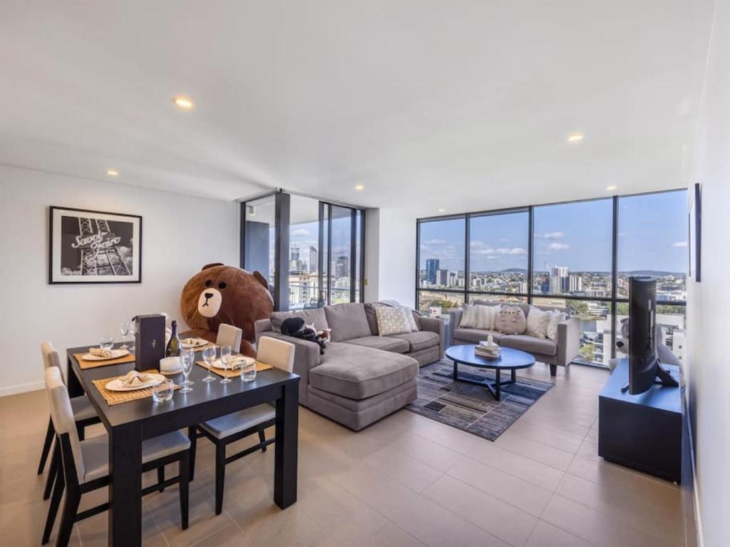 布里斯班Riverview 2BR delicate Apt, 1min to train station的客厅,桌子上摆放着泰迪熊