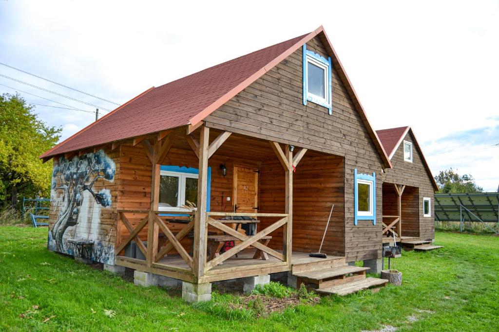 Cabaña de madera con techo rojo en nr.2 - W POLU DOBREJ ENERGII 