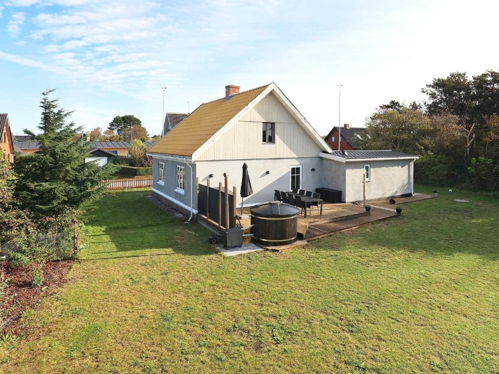 uma grande casa branca com um grelhador e um quintal em Holiday home Læsø IV em Læsø