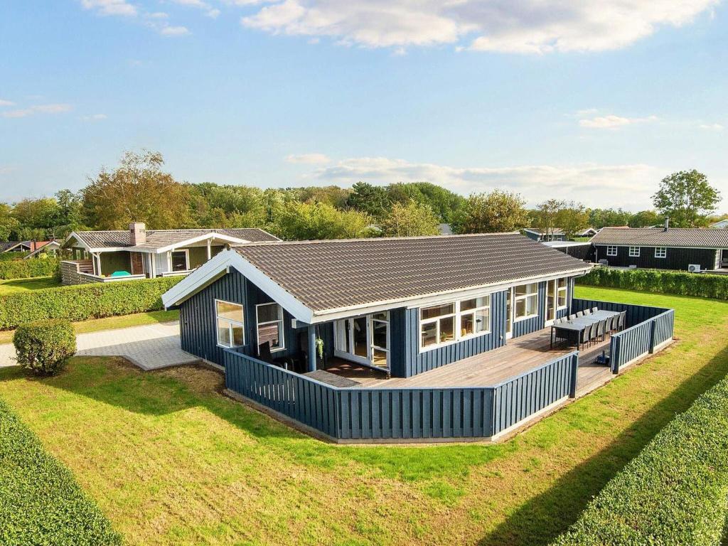 una gran casa azul con terraza en un patio en Holiday home Egernsund VI en Egernsund