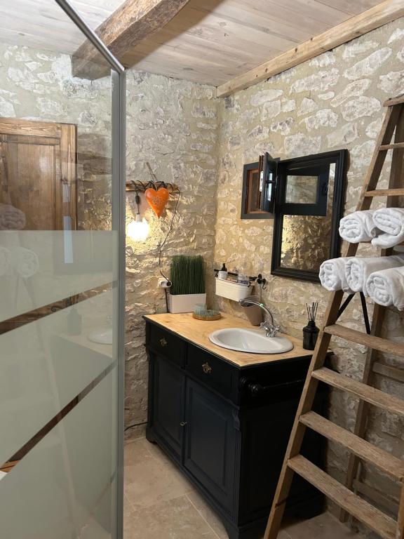 uma casa de banho com um lavatório, um espelho e uma escada em Les fontanelles du quercy blanc em Montcuq