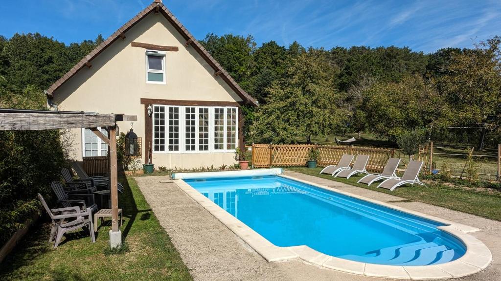 einen Pool mit Stühlen und ein Haus in der Unterkunft Au Bonheur de Cisse in Chouzy-sur-Cisse