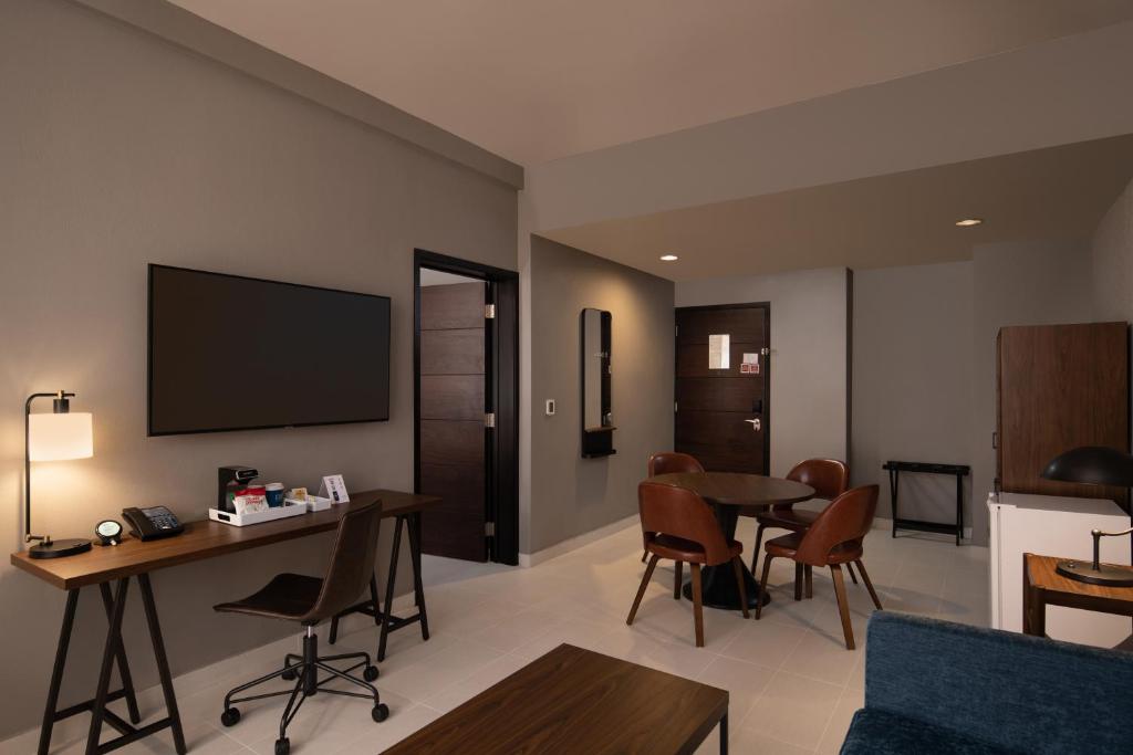 sala de estar con TV, mesa y sillas en Four Points by Sheraton , en Punta Cana