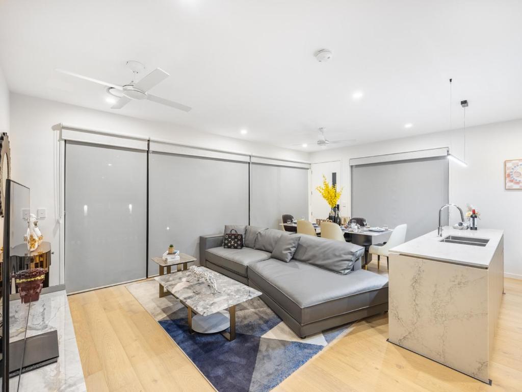a living room with a couch and a kitchen at Conveniently Located Luxury 4BR Townhouse in Brisbane