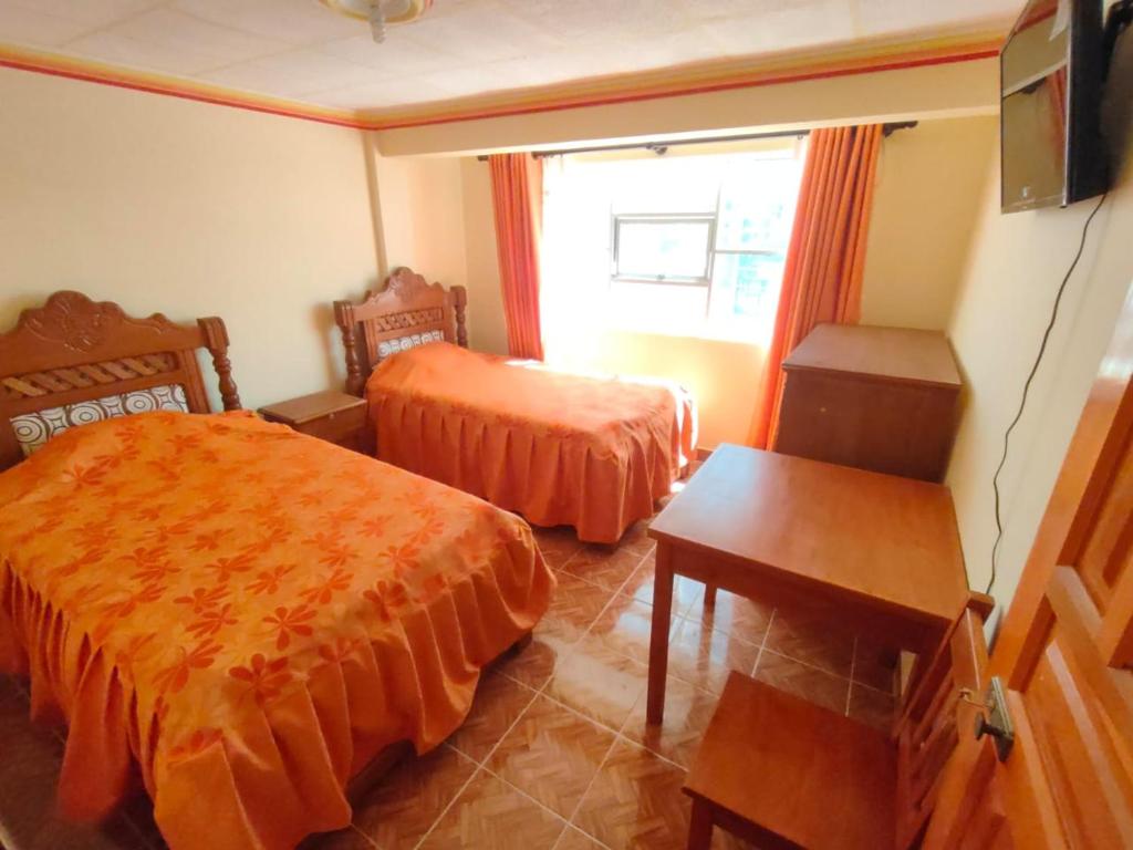 a hotel room with two beds and a window at Hostal Puesta de Sol in Uyuni