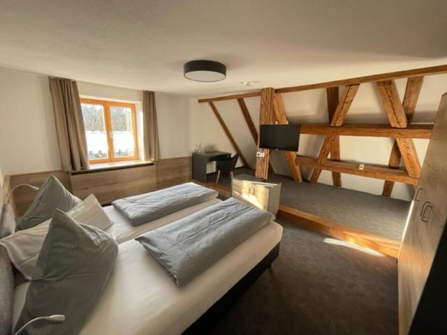 a bedroom with two beds and a large window at Gasthof zum Rößle Lautrach in Lautrach