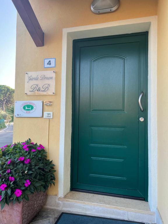 una porta verde di una casa con fiori di Garda Dream a Lazise