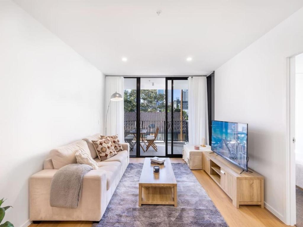 黄金海岸Comfortable 1BR Apt with pool and carpark的带沙发和电视的客厅